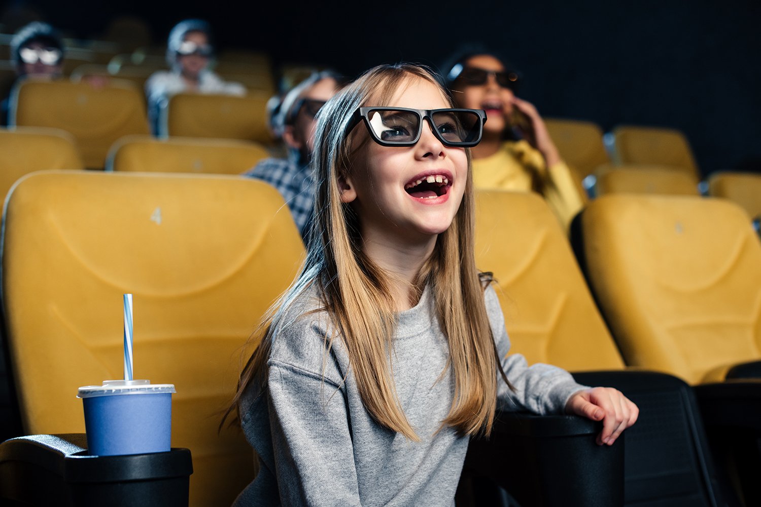 The picture shows a girl watching a movie at the cinema. Photo Pexels