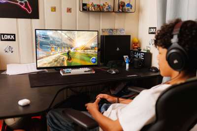 En gutt tidlig i tenårene sitter i en gamingstol og spiller. Vi ser ham skrått bakfra, og ser skjermen han spiller på foran ham.