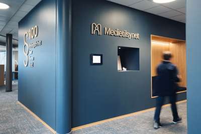 Inne i Medietilsynets kontorlokaler. Det står Medietilsynet på veggen.