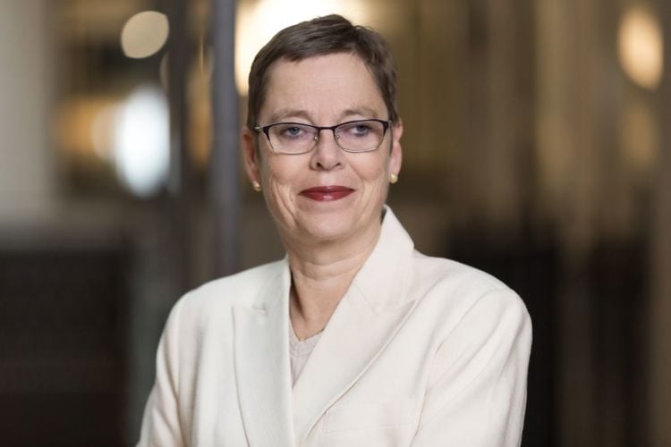 Portrett av Mari Velsand, direktør i Medietilsynet. Hun har kort hår, briller og røde lepper, og er kledd i en lys jakke. Bakgrunnen er uskarp og nøytral.