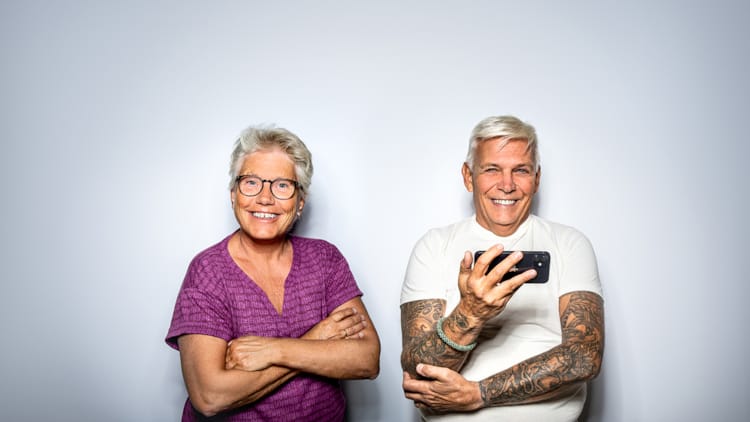 Eldre kvinne og eldre mann side om side - begge blide, mannen med mobil i hånden. Foto NTB/ Thomas Brun