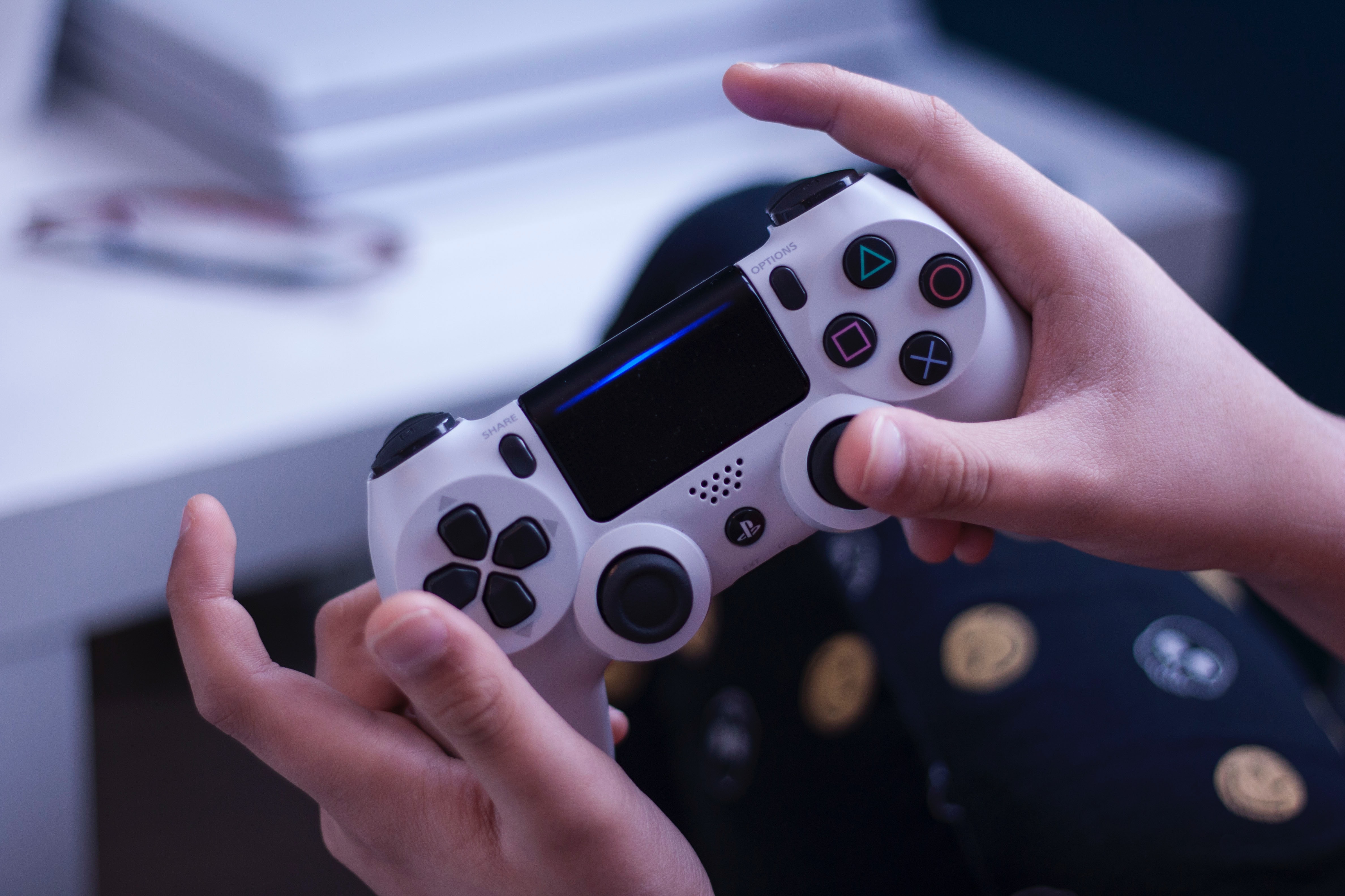 Hender som holder i en playstation-kontroll. Foto Unsplash